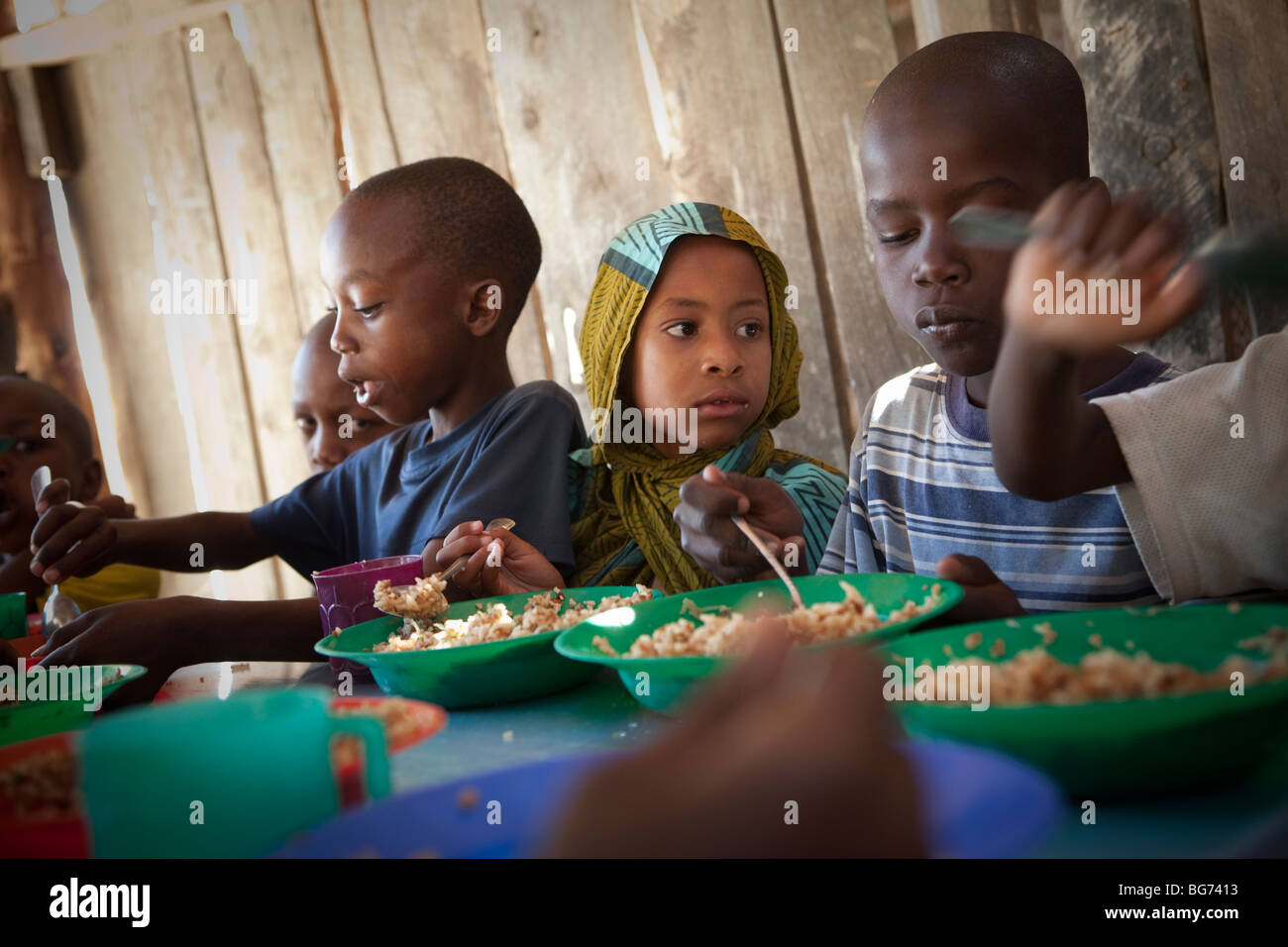 Kinder erhalten in Mererani, Tansania, die weltweit einzige Quelle der Tansanit Mahlzeiten in einer Küche. Stockfoto