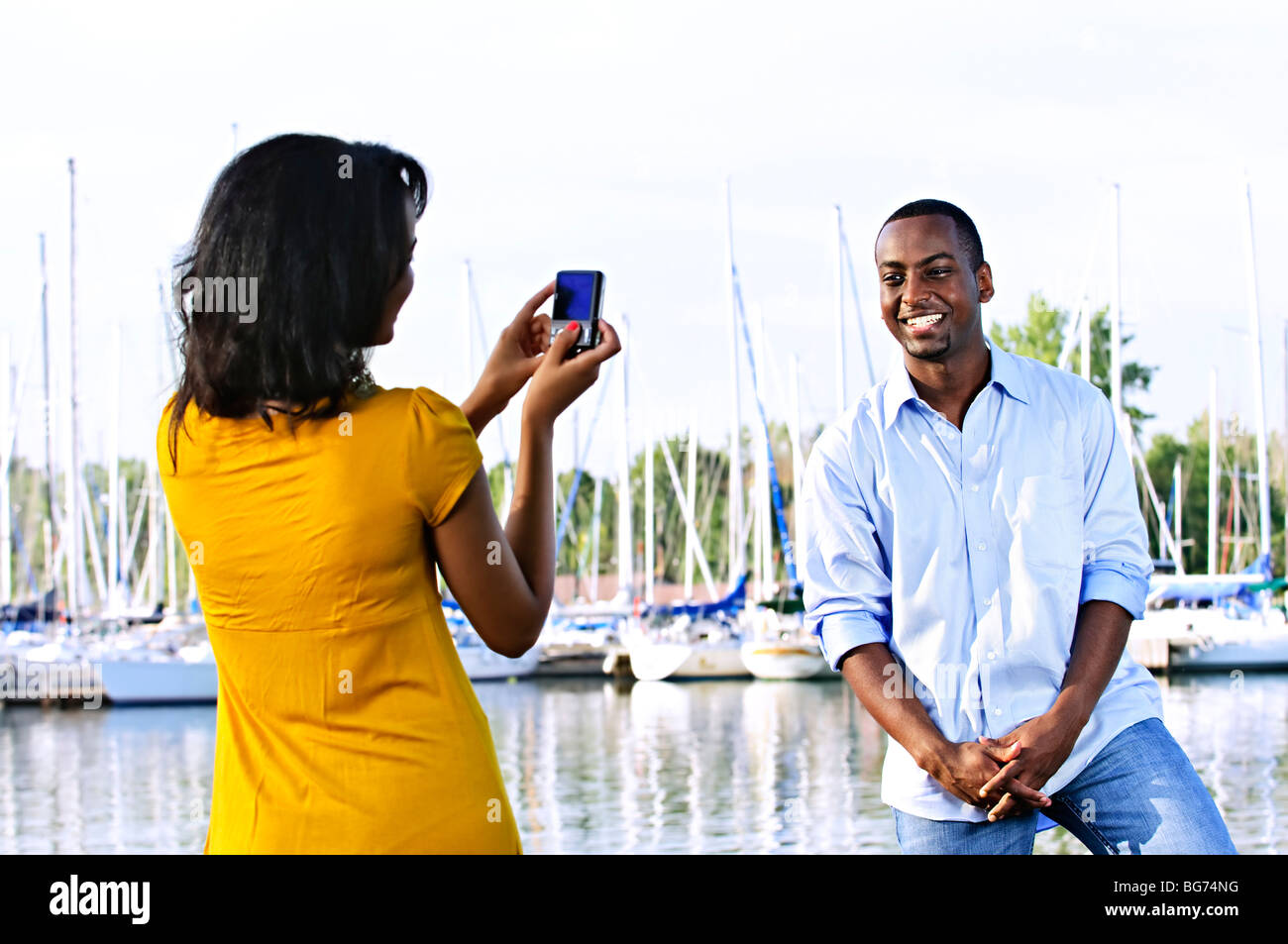 Gut aussehender Mann posiert für Urlaubsfoto am Hafen mit Segelbooten Stockfoto