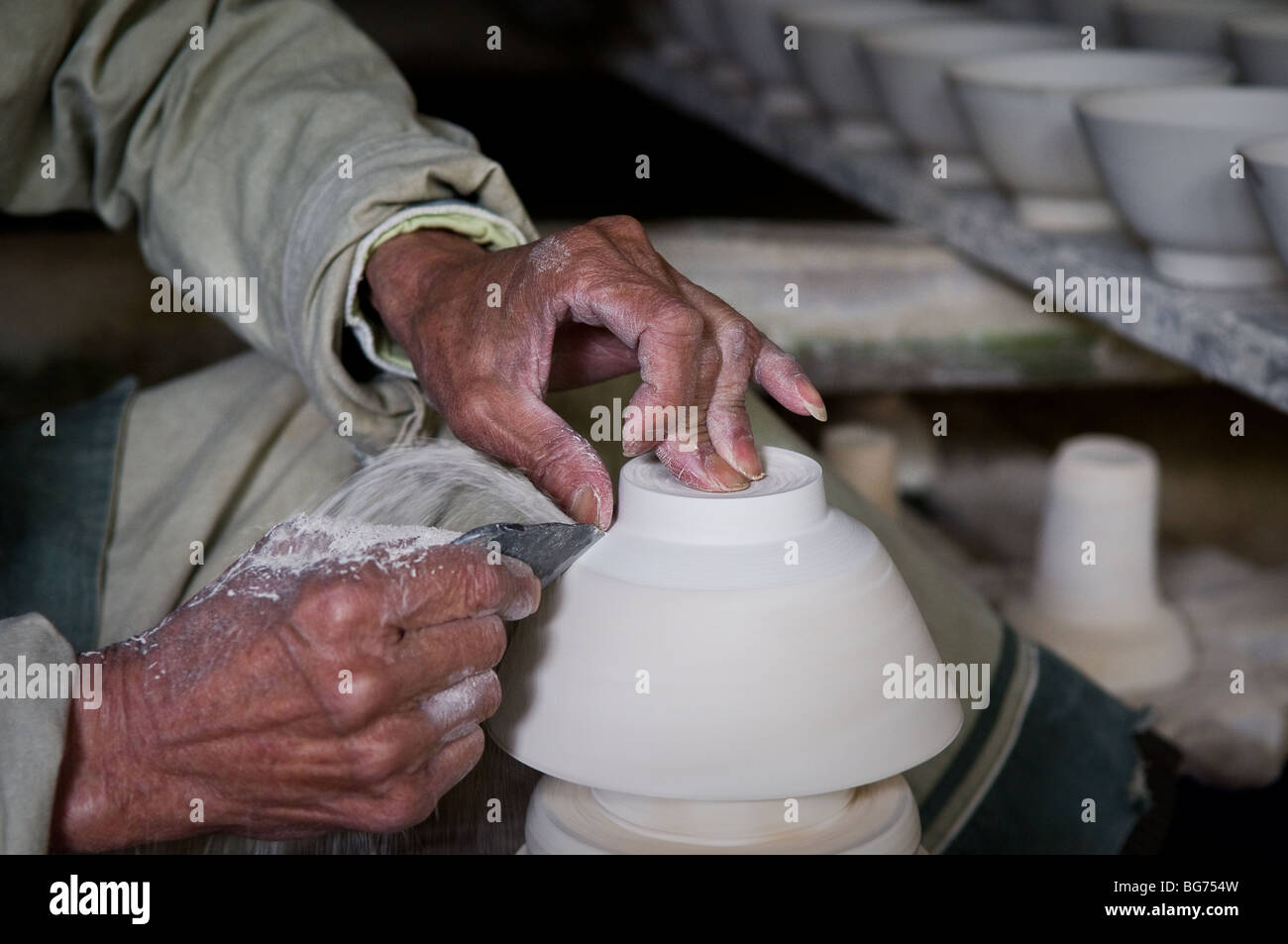 Nahaufnahme eines Keramik-Arbeitnehmers Schnitzen einer Schüssel in China Stockfoto