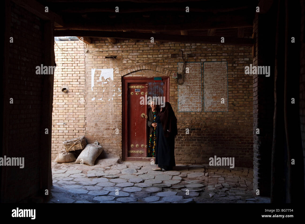 Zwei Womenatg der Eingang, ein traditionelles Haus in der alten Stadt Kashgar, Provinz Xinjiang, China Stockfoto