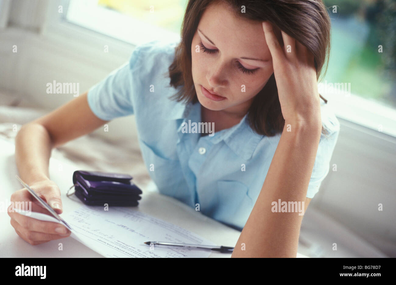 junge Frau mit Kreditkarten schauen besorgt Stockfoto