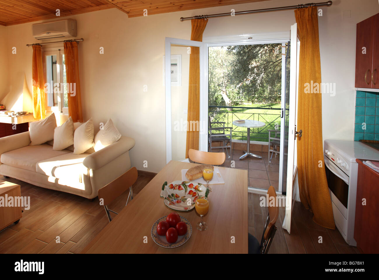 Innenraum einer typischen Ferienvilla Unterkunftstyp lounge mit einem angrenzenden Essbereich und kleine Küche. Griechische Inseln Stockfoto