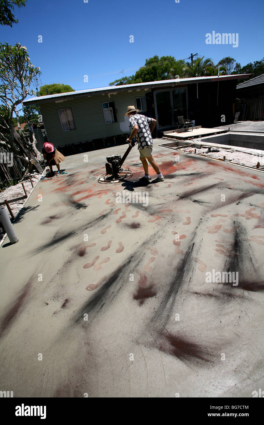 Verbreitung von Ocker auf frisch gelegten Beton bringt Farbe an die Oberfläche. Stockfoto