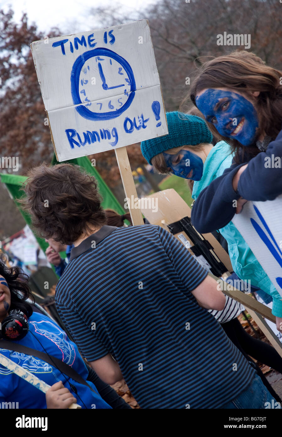 Ein Demonstrant lächelt wie ein anderes hält eine hausgemachte Plakat Stockfoto