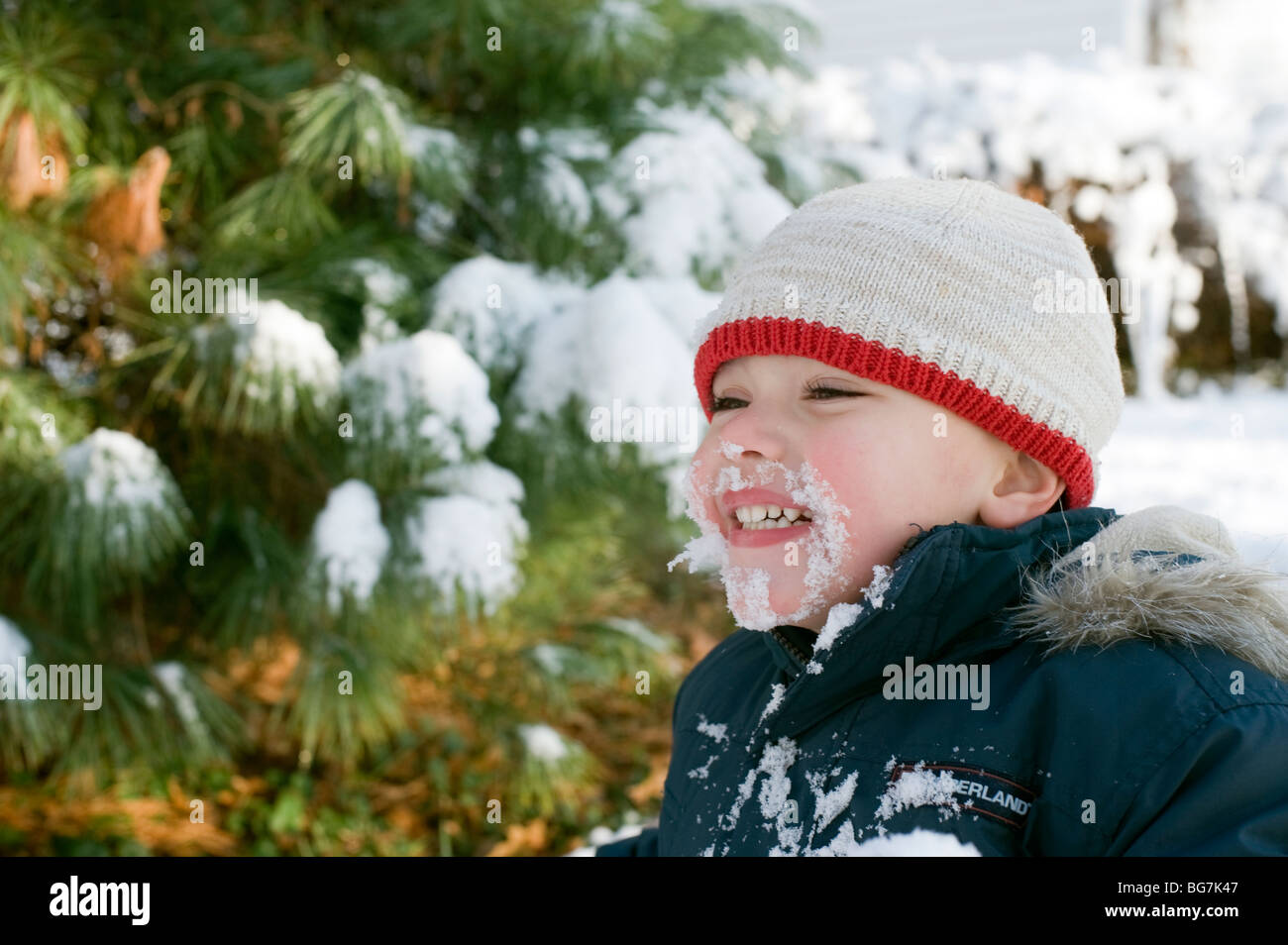 4 Jahre alten Hispanic junge spielt im frisch gefallenen Schnee in seinem Vorgarten mit seiner Mutter. Bild ist Modell veröffentlicht. Stockfoto