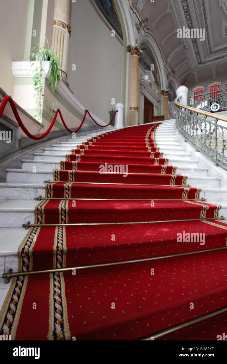 Marmor-einen Schritt, der von einem roten Teppich abgedeckt Stockfoto