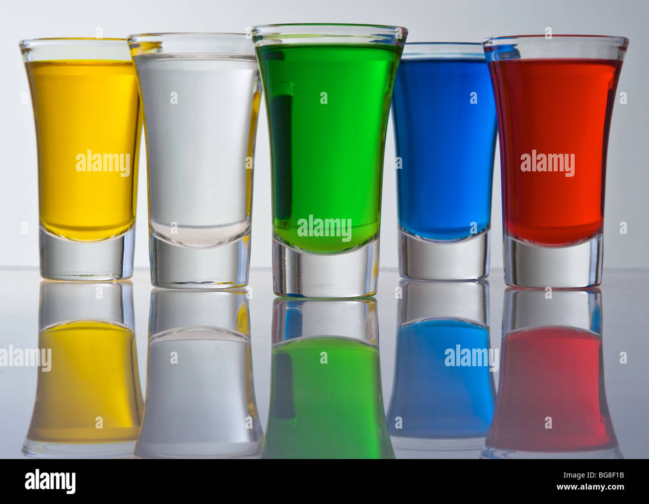 Stillleben aus fünf kleinen Haufen aus dem Glas gefüllt Farbe Cocktails mit Überlegung Stockfoto
