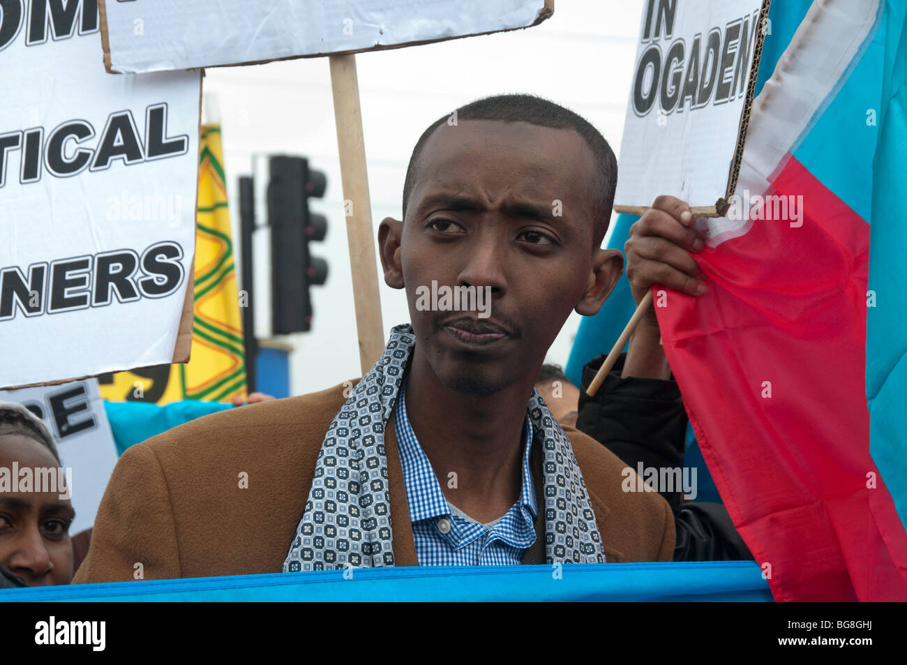 Schwarze Afrikaner aus Protest umgeben von Plakaten und Flagge am G20-Protest gegen äthiopischen Ogaden und Oromo Stockfoto