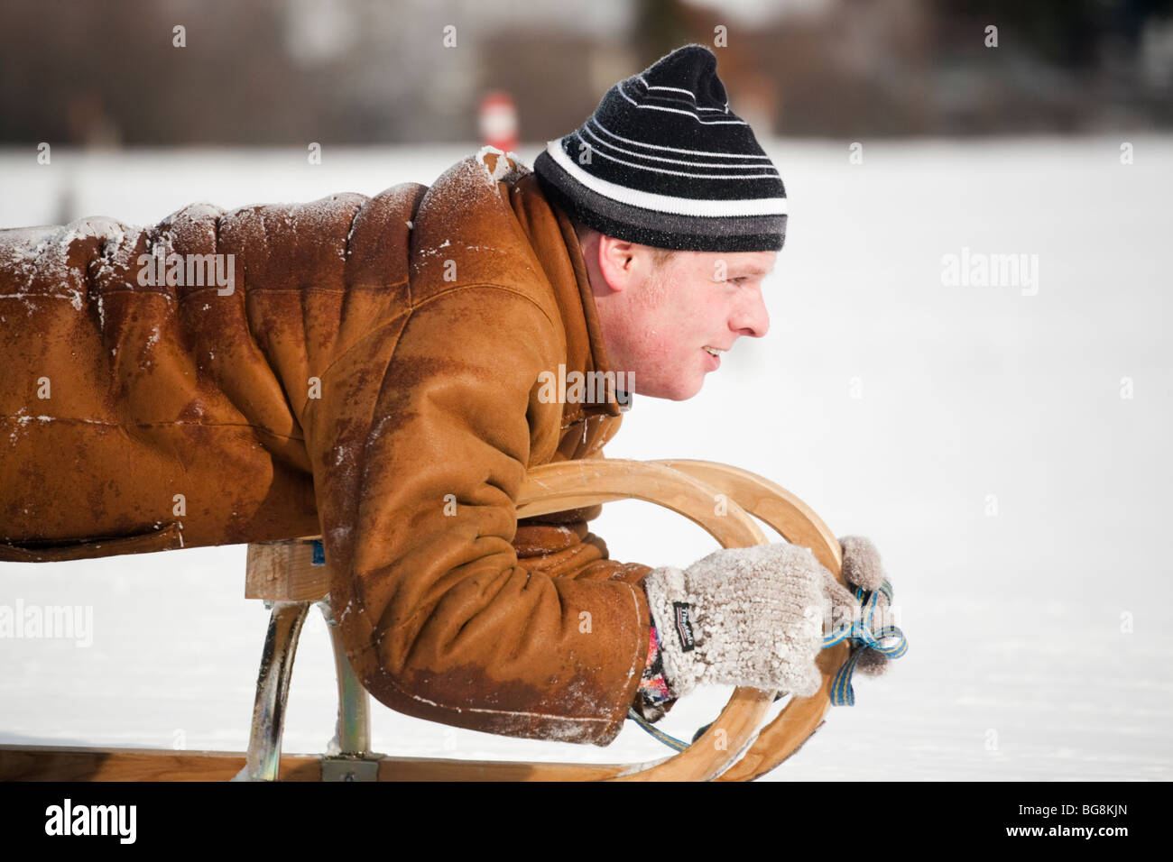 Mann rodeln auf Schnee Schlitten. Rauris Österreich Europa. Stockfoto