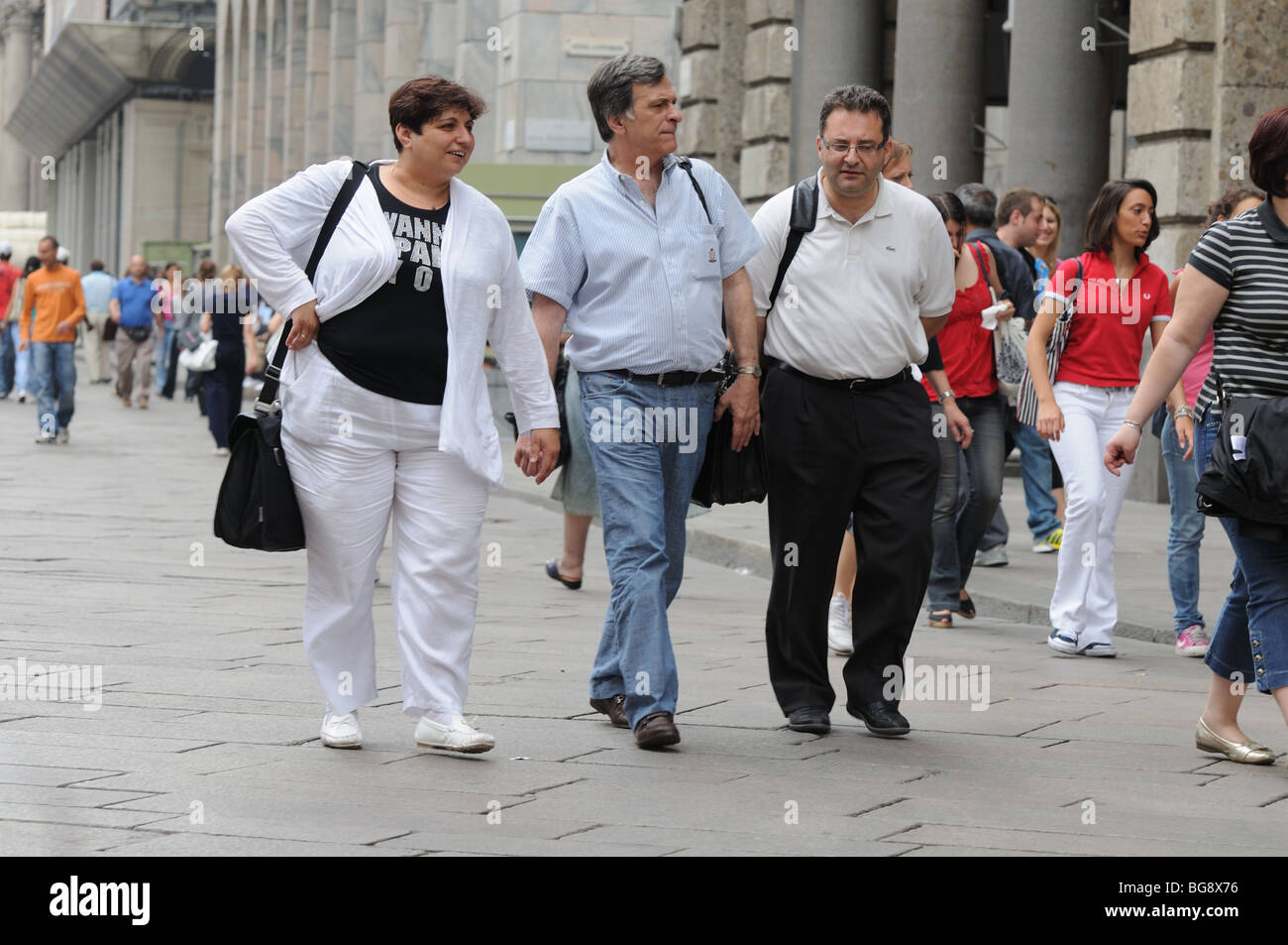 Drei übergewichtige Besucher tragen Schulter Taschen auf der Piazza del Duomo Milan Mailand Italien Italia Stockfoto