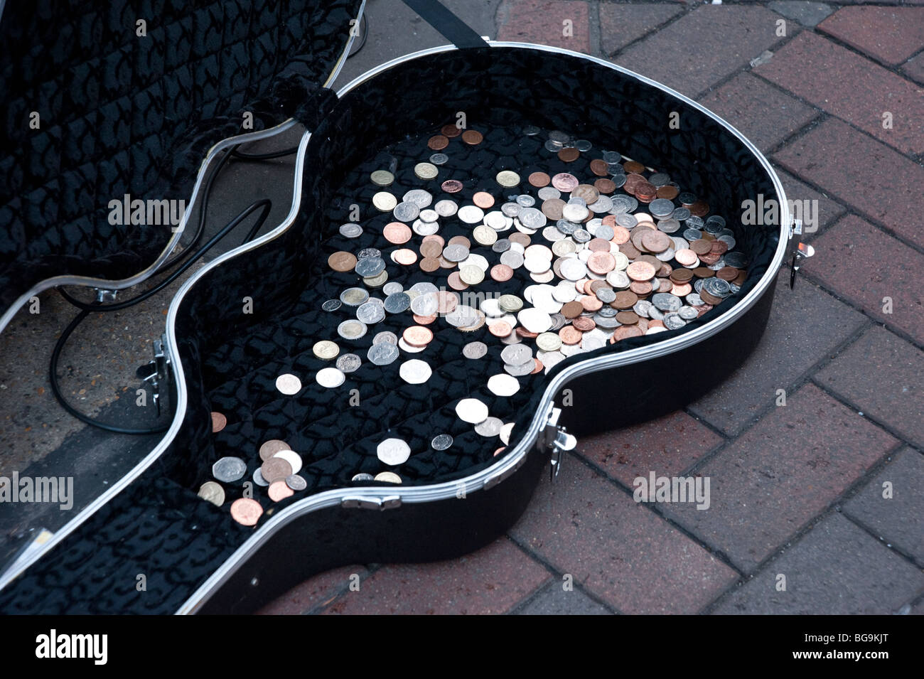 Münzen in der Straßenmusikant Gitarre Fall, London, England, UK Stockfoto