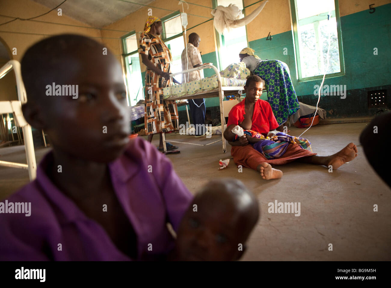 Patienten sitzen auf dem Boden eines Krankenhauses in Amuria, Uganda, Ostafrika Stockfoto