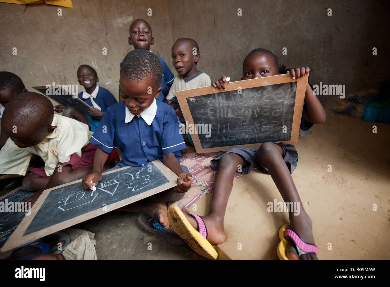 Junge Kinder malen auf Tafeln in einem Waisenhaus in Amuria, Uganda, Ostafrika. Stockfoto