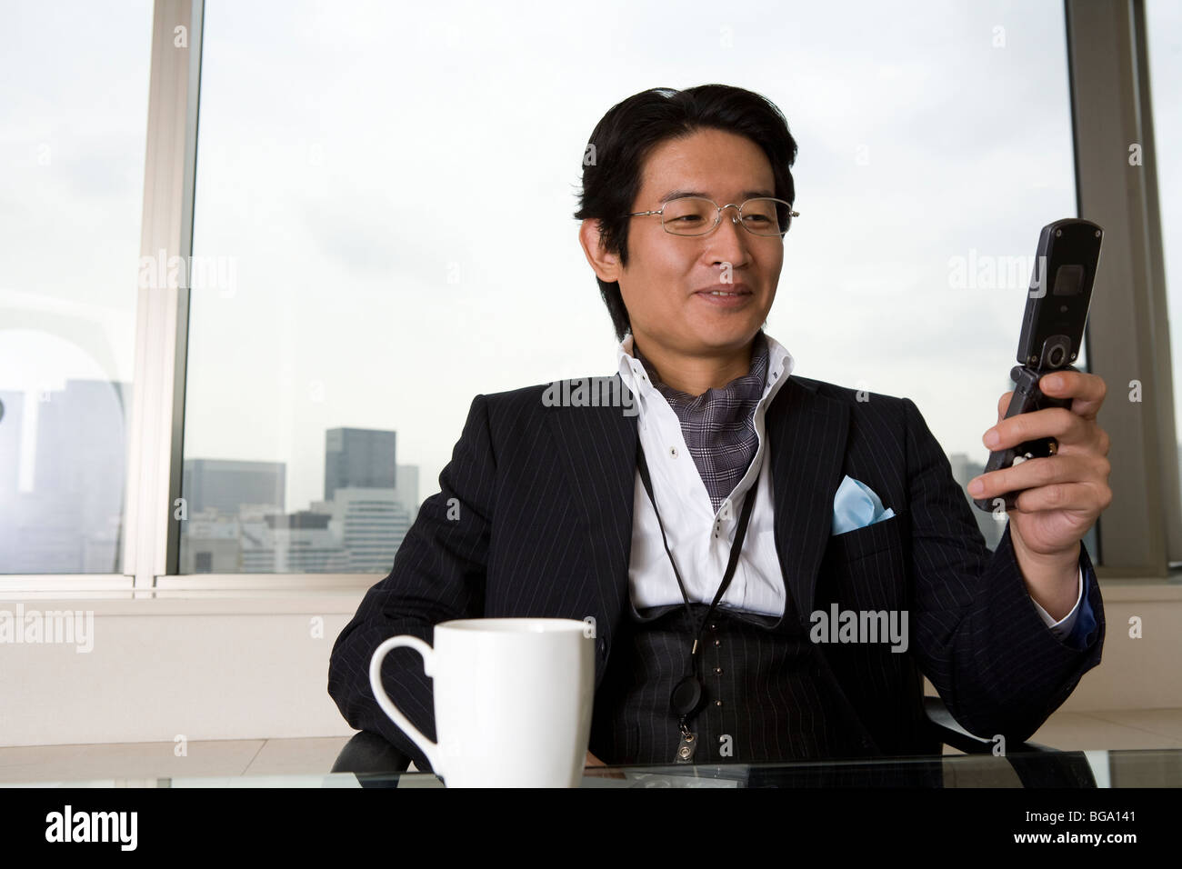 Reifer Mann Blick auf Handy Stockfoto