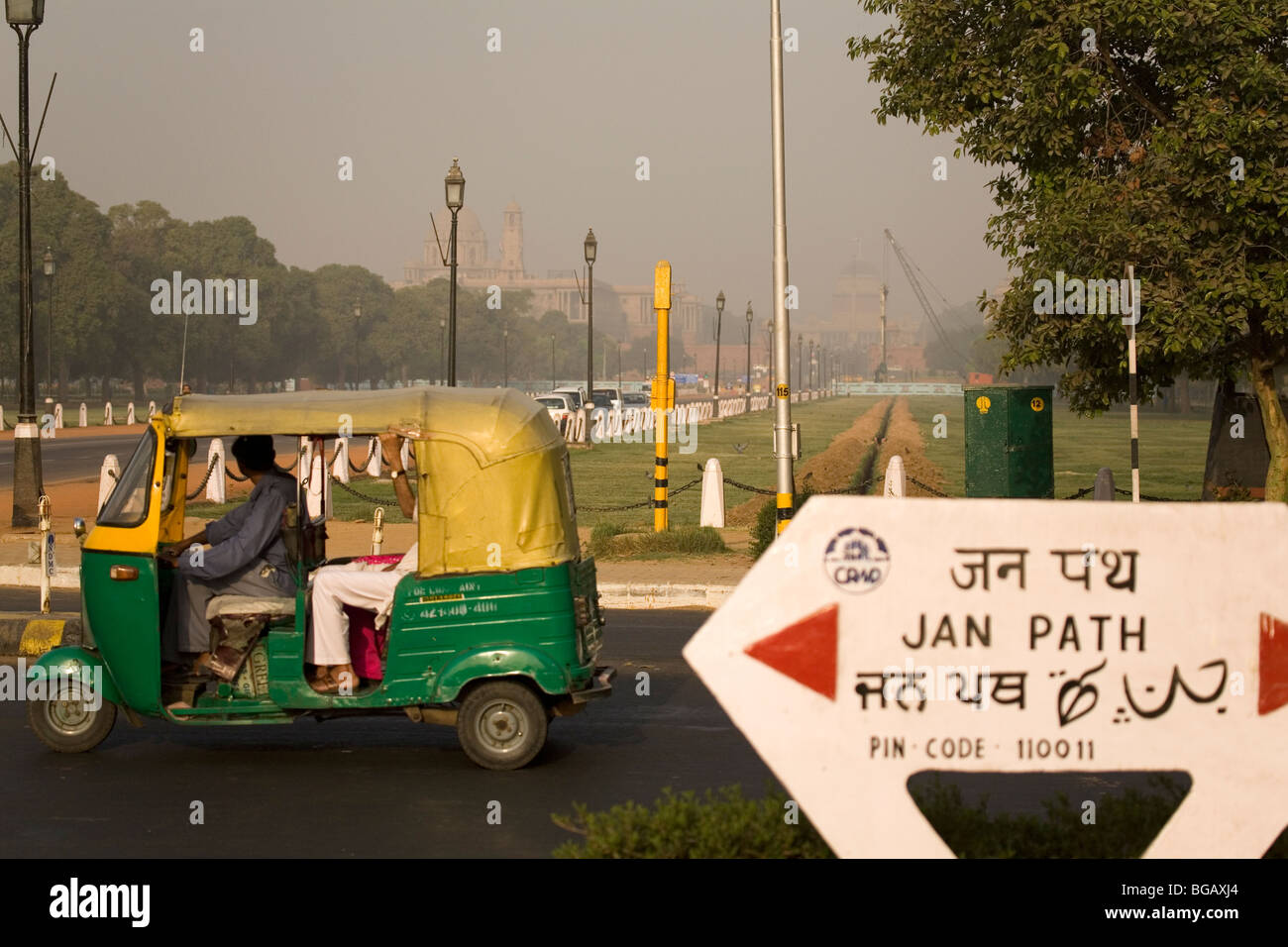 Eine Rikscha zieht sich aus der Jan Path an einem dunstigen Morgen in New Delhi, Indien. Stockfoto