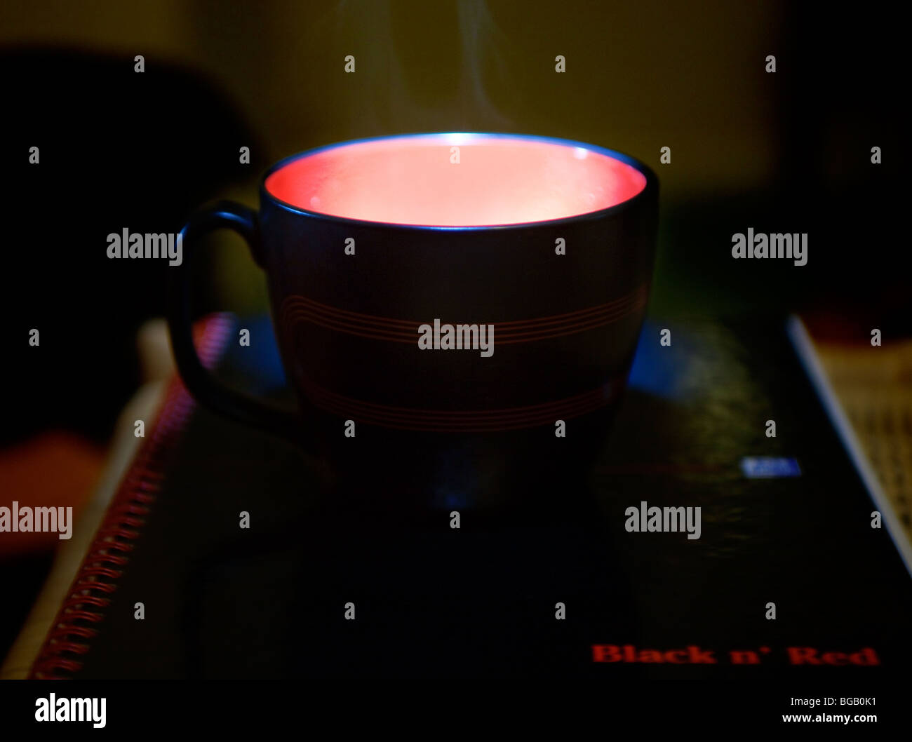 Leuchten von Teetasse auf Notizbuch Stockfoto