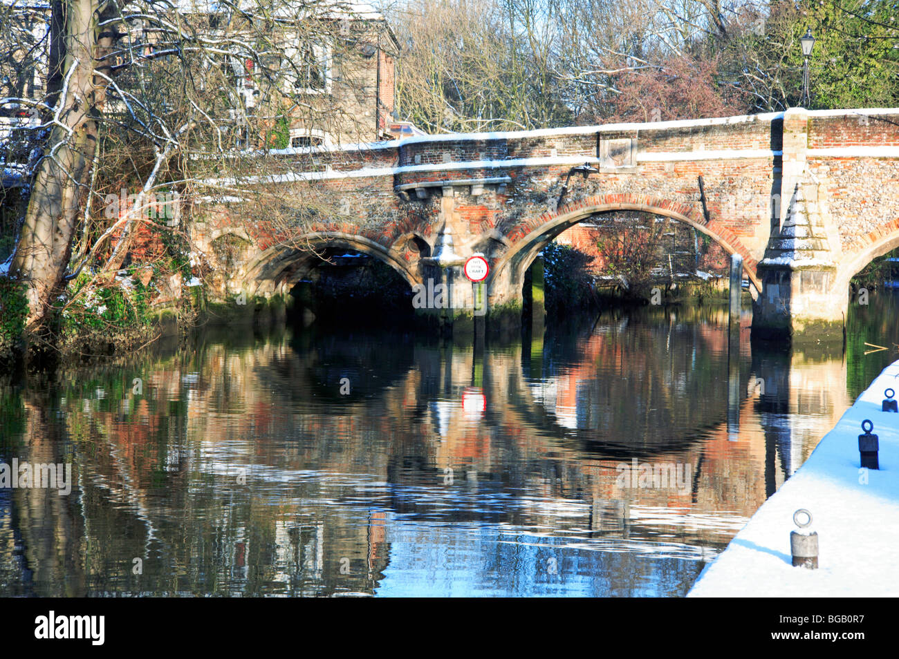 Brücke und Reflexionen in den Fluss Wensum in Norwich, Norfolk, Großbritannien, nach Übernachtung Schneefall des Bischofs. Stockfoto