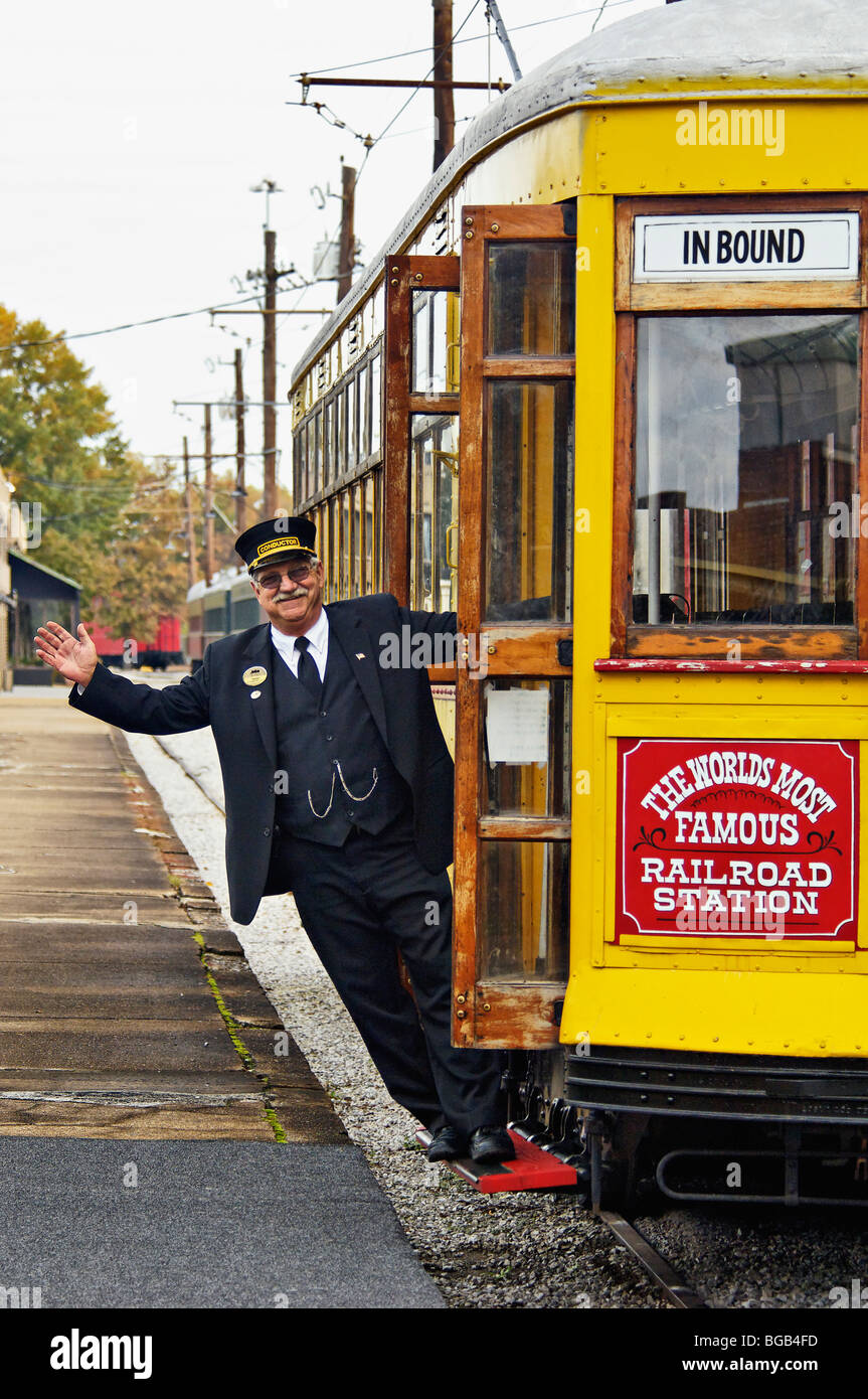 Während auf der Seite des einen Trolley bei Chattanooga Choo Choo Depot in Chattanooga, Tennessee hanging Trolley Dirigent winken Stockfoto