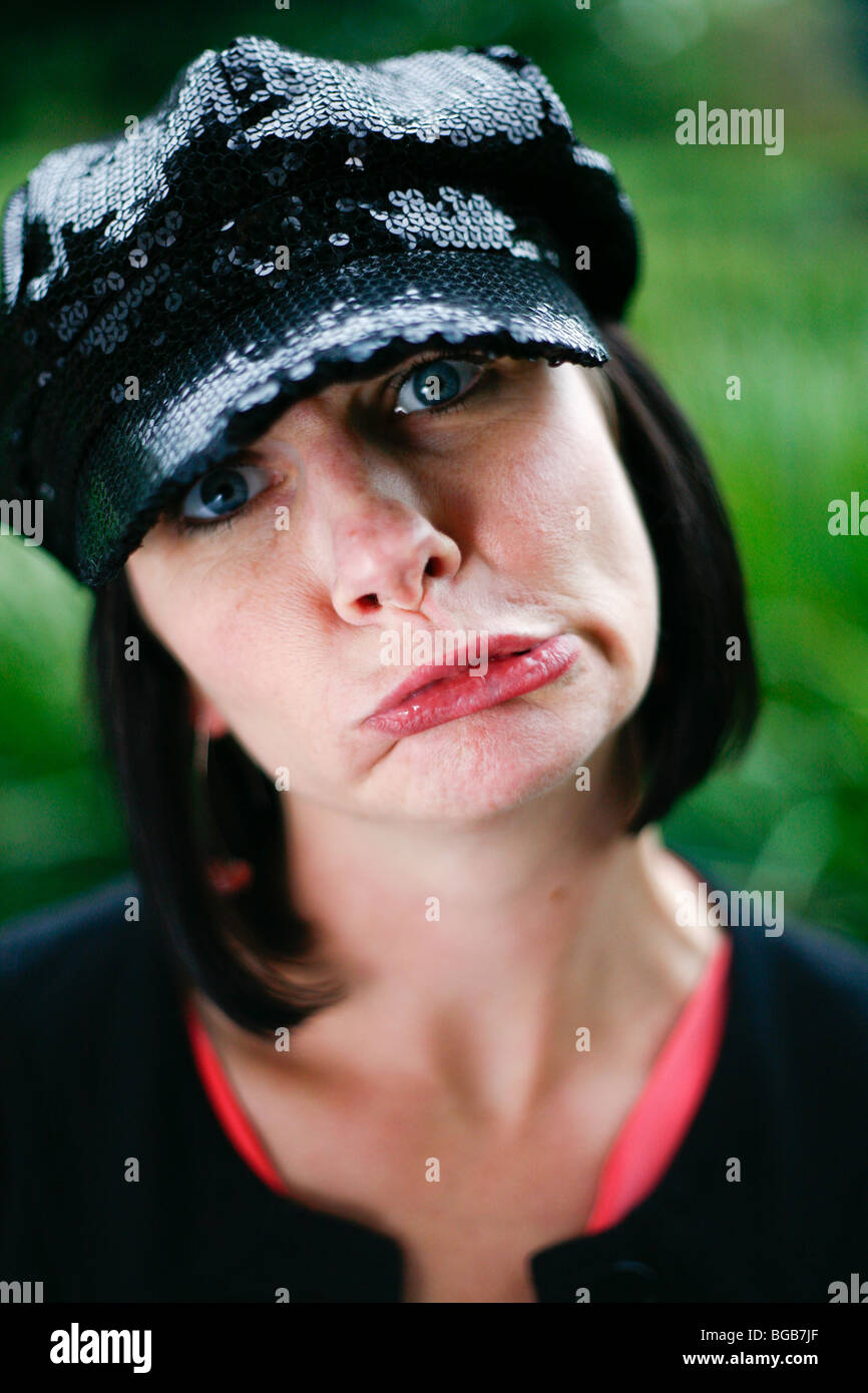 Brünette Frau mit schwarzen Pailletten Hut Grimassen. Stockfoto