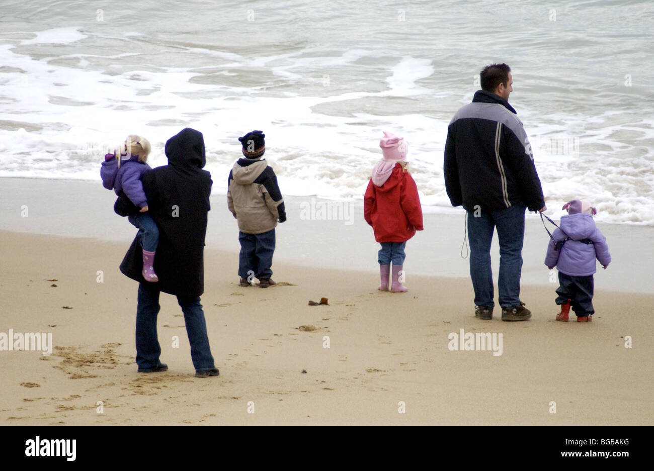 Familie am Strand mit Blick auf das Meer Stockfoto