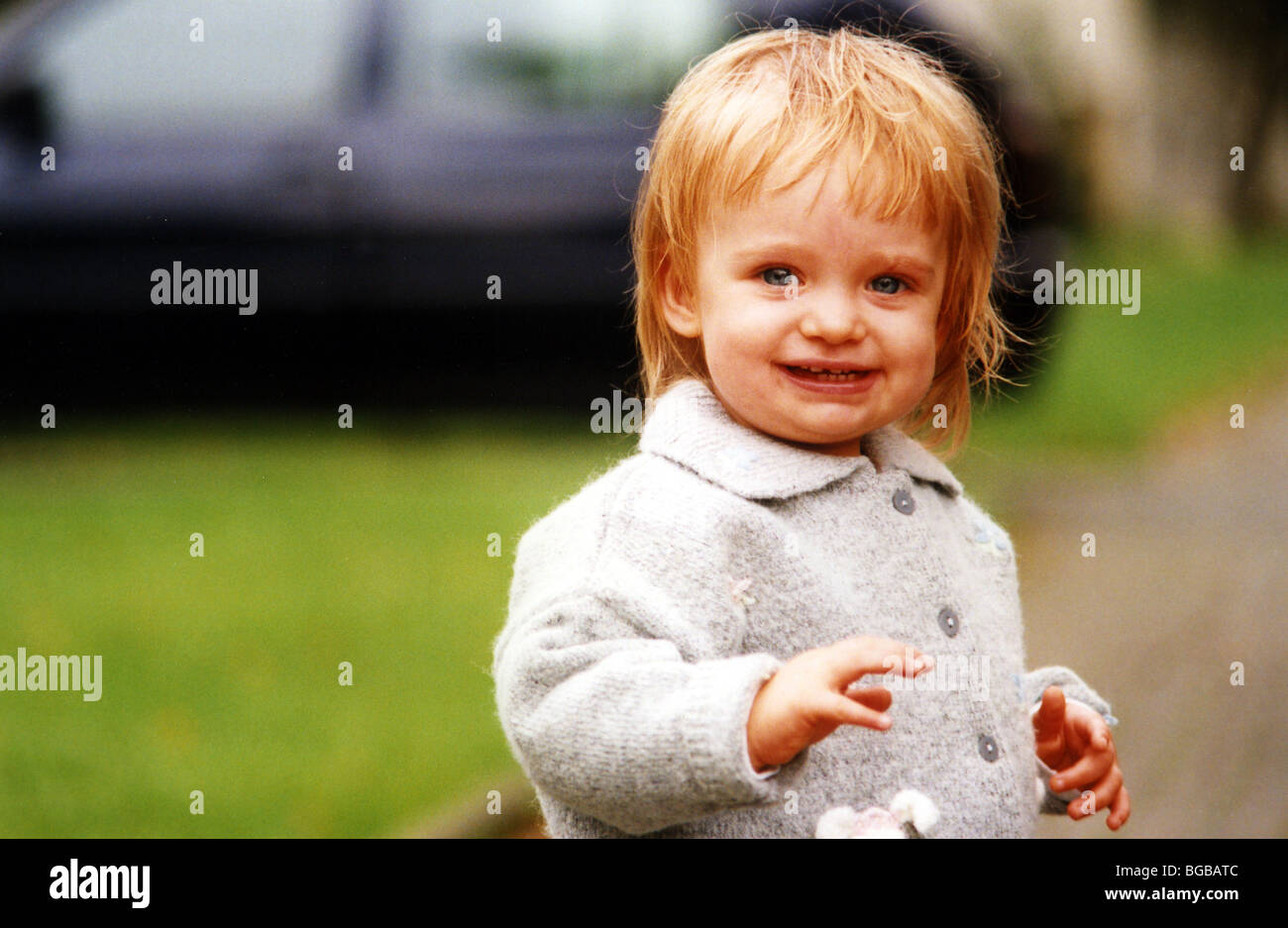 Foto von jungen Mädchen außerhalb Lächeln glücklich zu Fuß Kleinkind UK Stockfoto