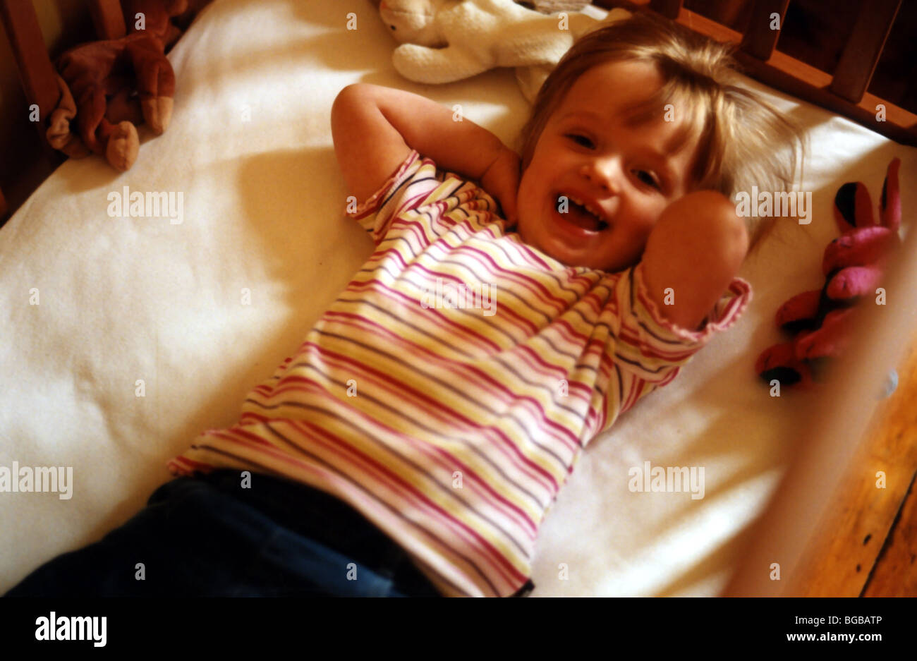 Foto des Kindes in Babys Kinderbett Lachen Lachen Lächeln verlegen Stockfoto