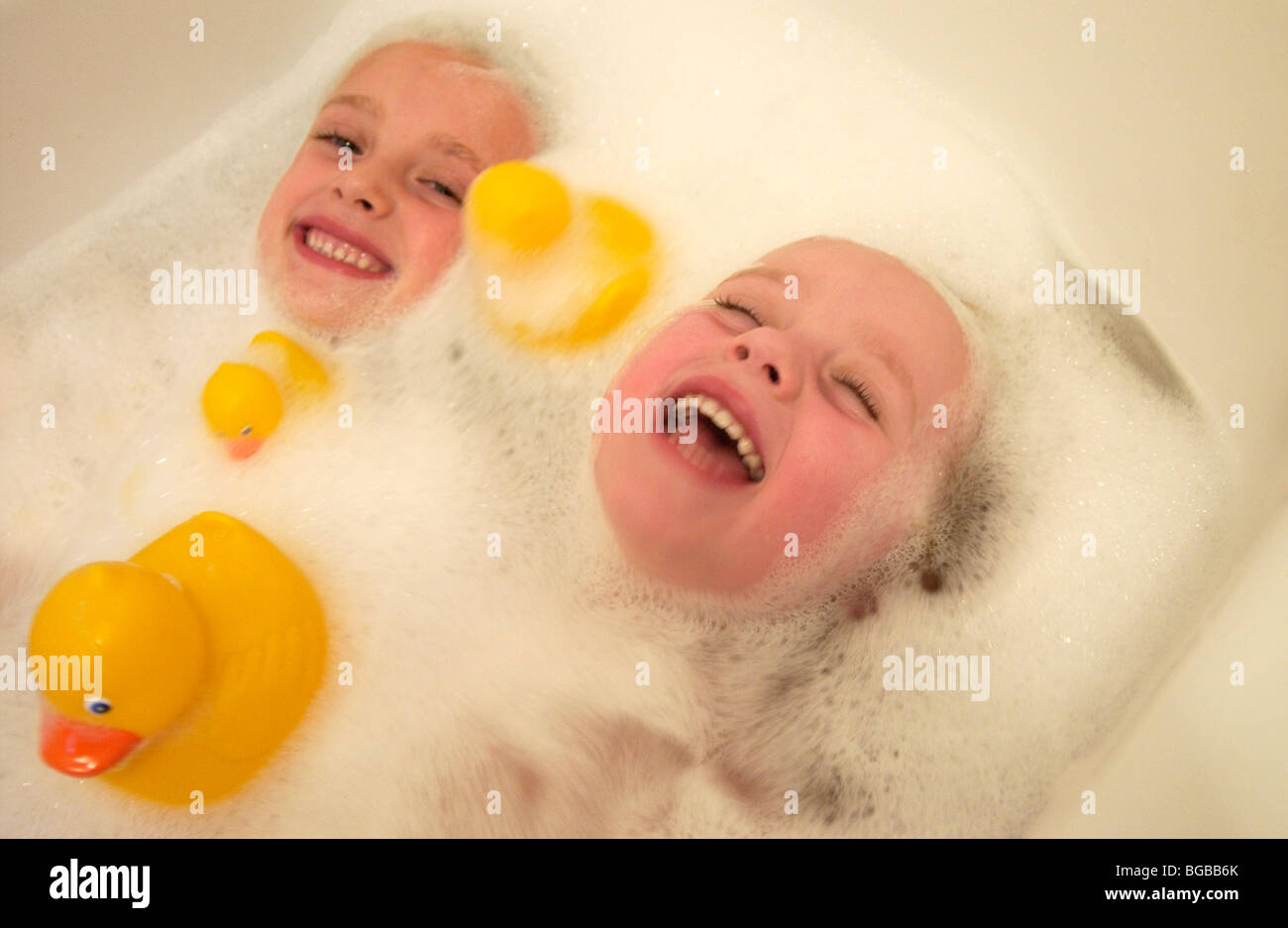 Lizenzfreie kostenlose Foto von zwei Kindern im Schaumbad Spaß mit Gummienten Stockfoto