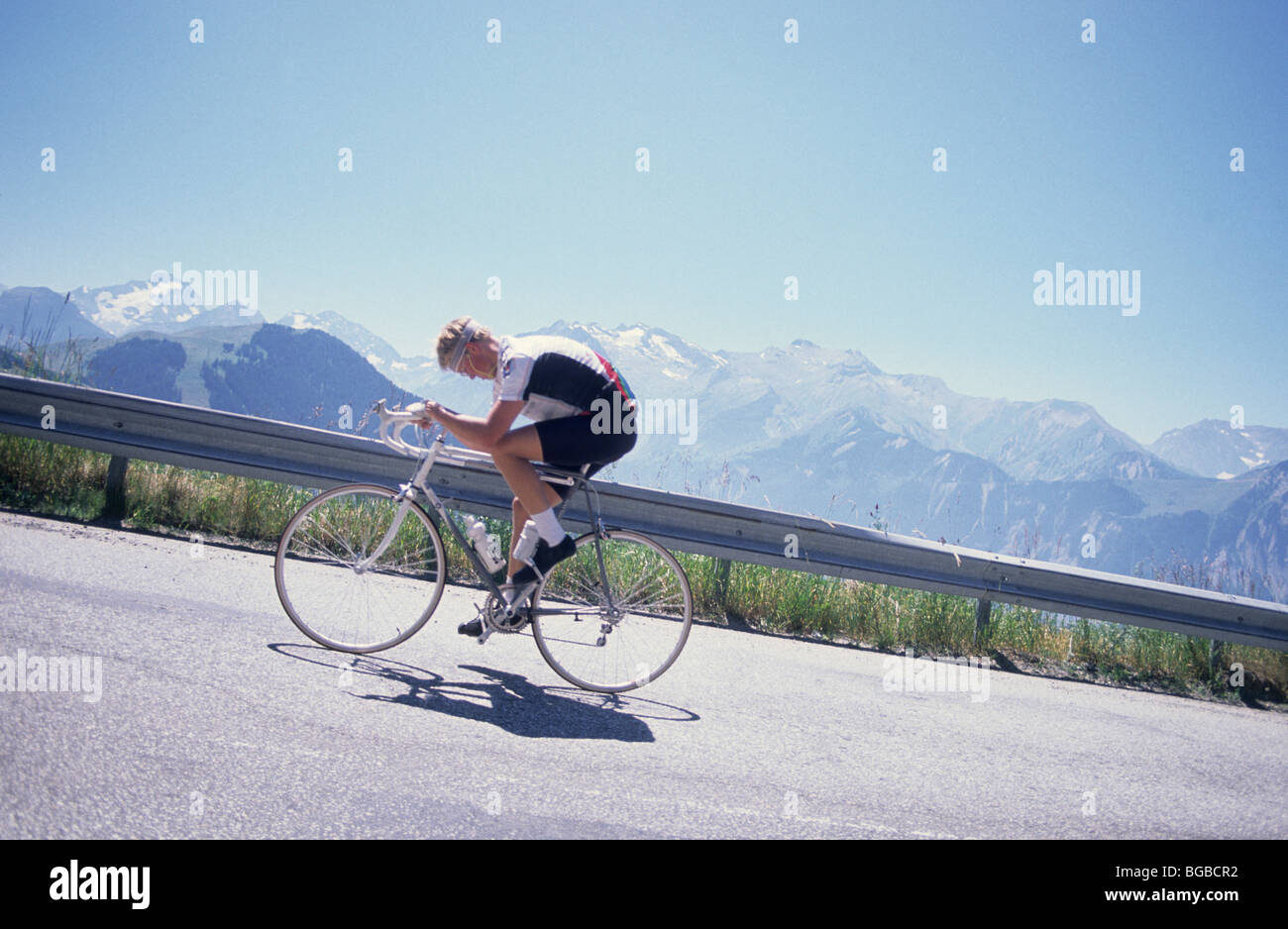 Einsame Radfahrer bergauf auf einer Bergstraße Stockfoto