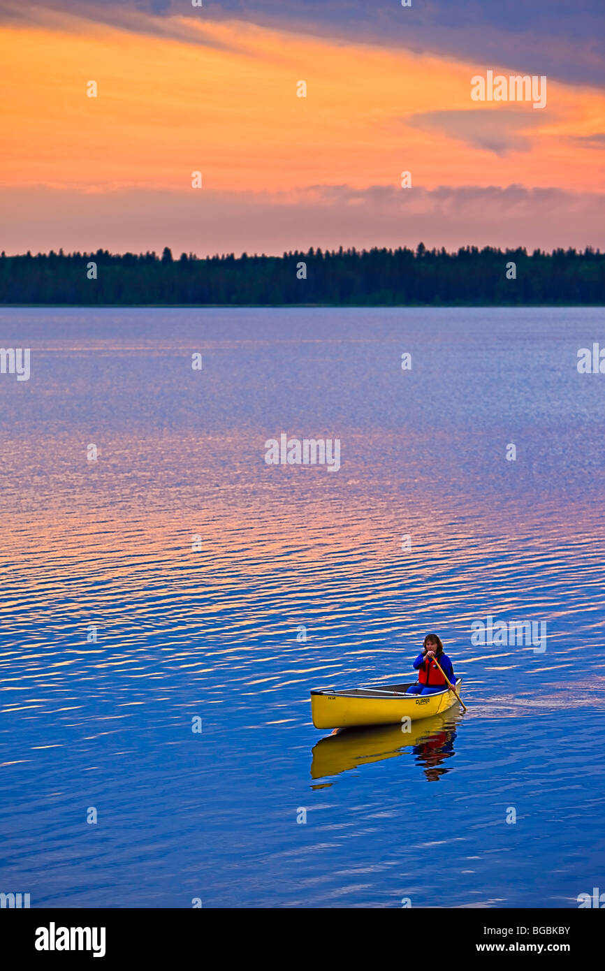 Kanufahren auf Lake Audy bei Sonnenuntergang im Riding-Mountain-Nationalpark, Manitoba, Kanada. -Modell veröffentlicht. Stockfoto