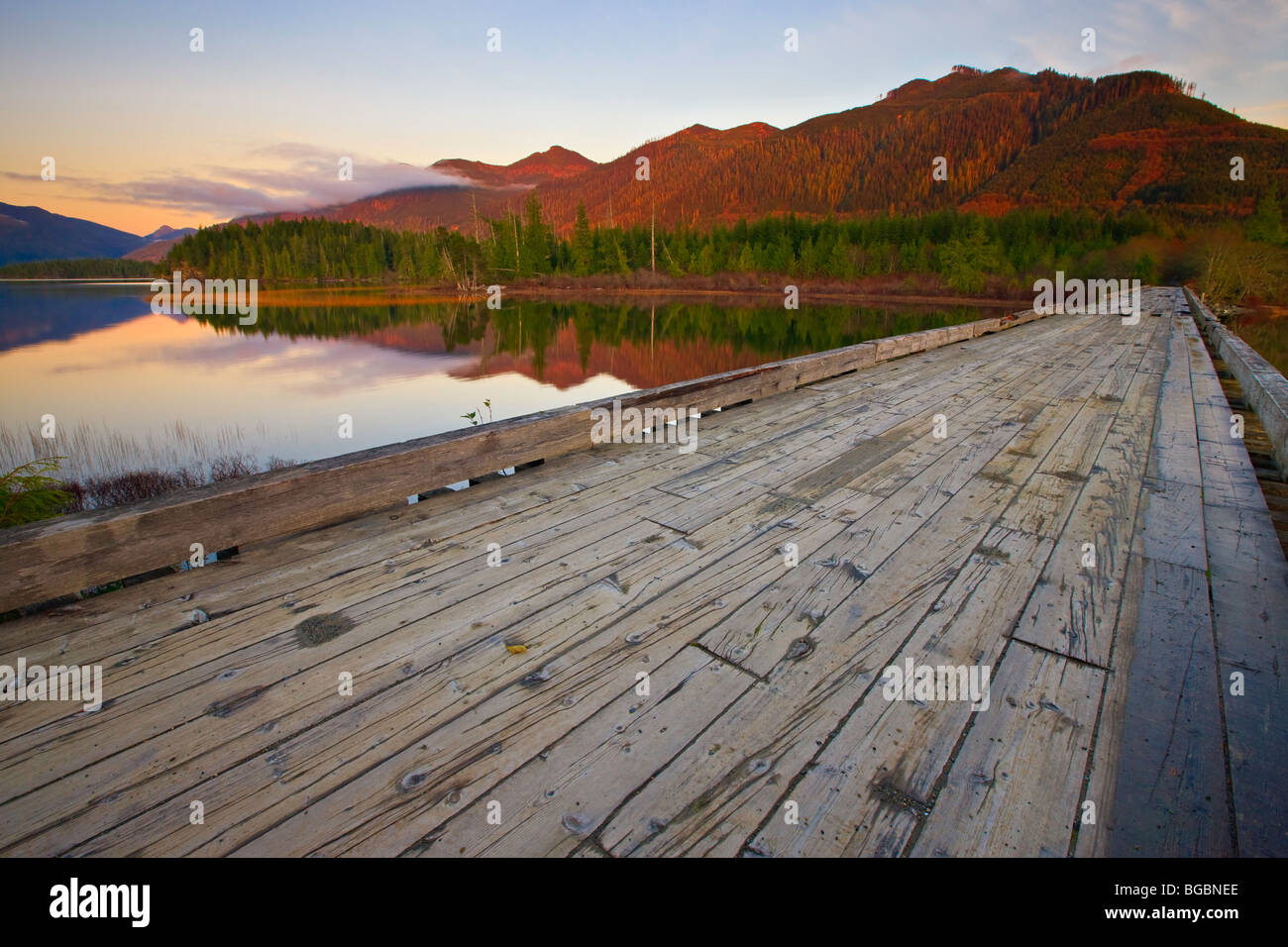 Alte hölzerne Brücke über den Eingang zum Clayoquot Arm des Kennedy Lake bei Sonnenuntergang, einem Übergangsbereich von den Clayoquot Sound UNE Stockfoto