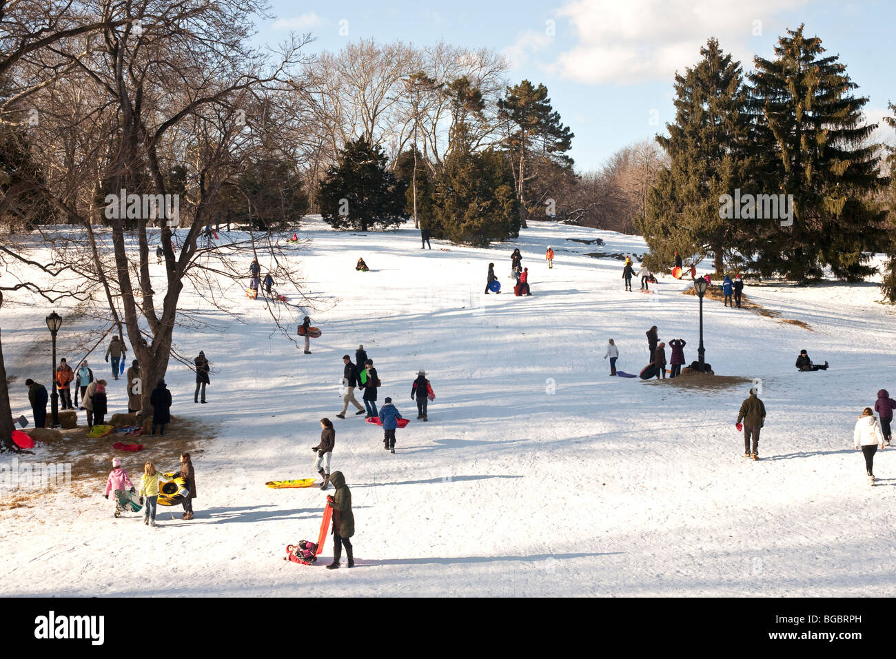 Winter-Szene auf Schnee bedeckt Rodelbahn im Central Park mit Kinder Teens & Erwachsene genießen einen sonnigen Wintertag in New York City Stockfoto