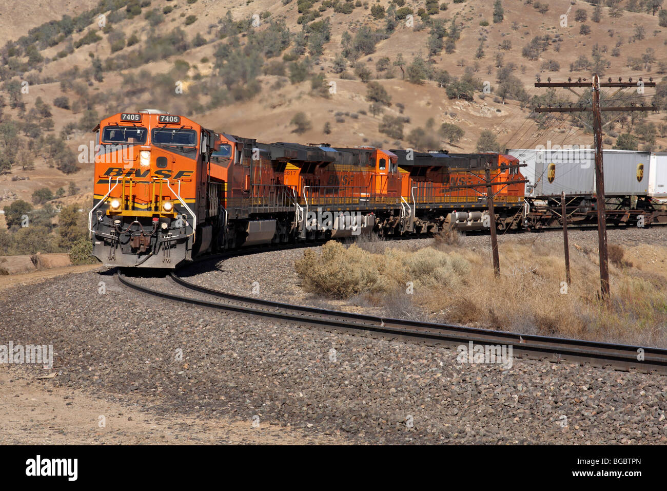 Ein BNSF Güterzug unter der Leitung von GE ES44DC Lokomotive 7405 gebaut klettert die Note in der Nähe von den Tehachapi Loop ostwärts. Stockfoto