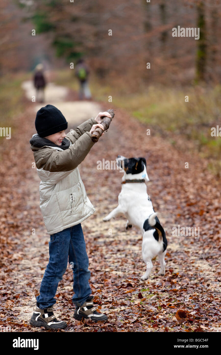 Ein Junge, 7 Jahre, mit seinem Hund spielen Stockfoto