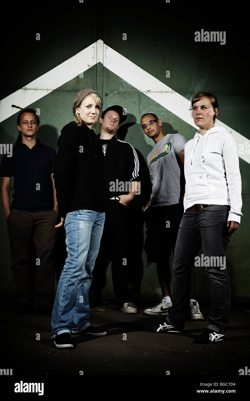 Gruppe von Jugendlichen vor einem alten Stahltor, Jugend, Gruppe, cool Stockfoto