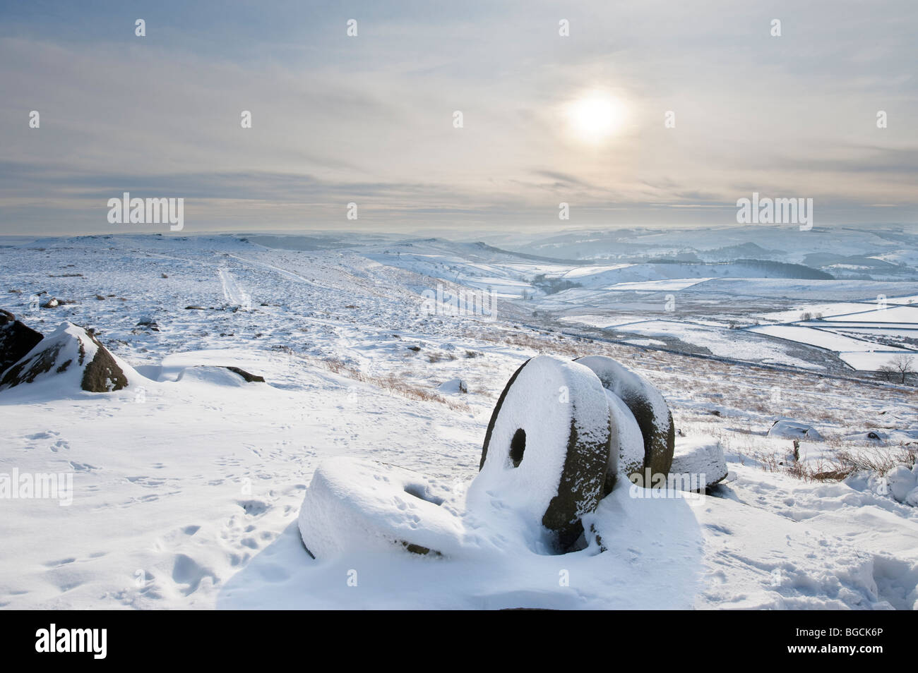 Aufgegeben von Mühlsteinen im Winter Schnee unter "Stanage Edge" in "Peak District", Derbyshire, Großbritannien, Großbritannien Stockfoto
