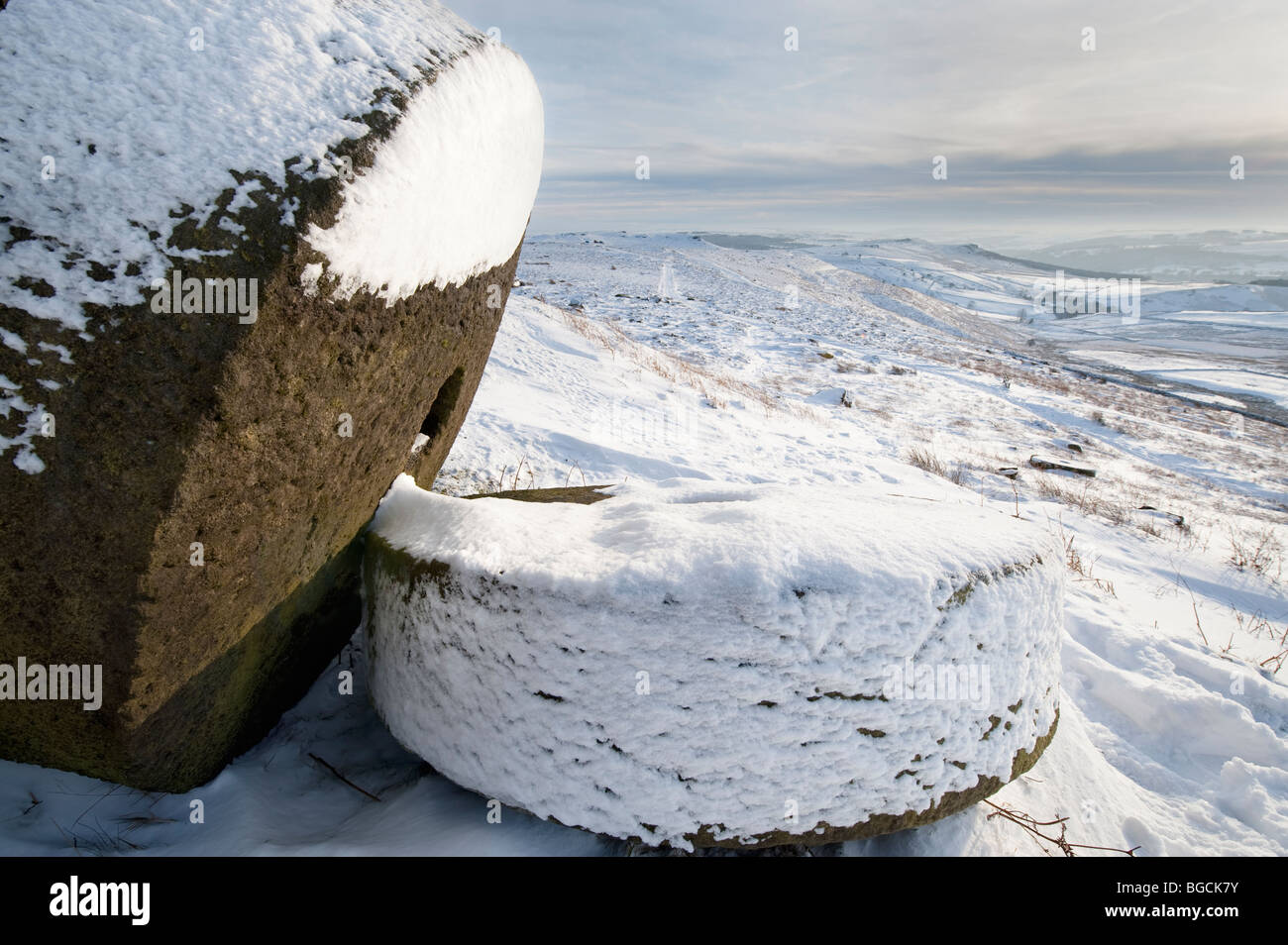 Zwei Mühlsteine im Winter Schnee unter "Stanage Edge" in der "Peak District", Derbyshire, England, Großbritannien Stockfoto