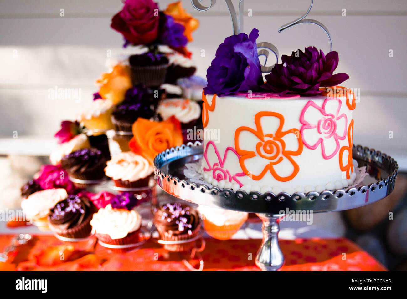 Hochzeitstorte auf silbernen Tablett mit Cupcakes dekoriert Stockfoto