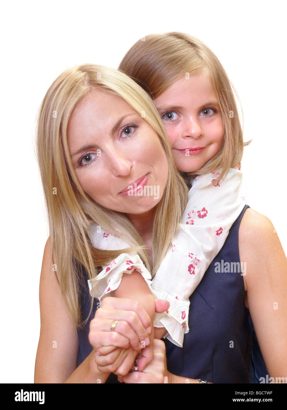 Junge Mutter und ihre süße kleine Tochter posiert auf weißem Hintergrund Stockfoto