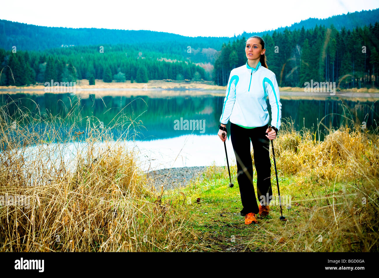 Junge Frau tun, Nordic-walking am See Stockfoto