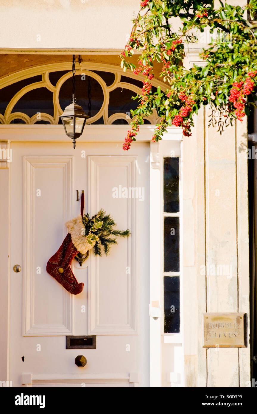 Traditionelle Regency Haus mit gestickten Weihnachts-Strumpf mit Holly an die Tür hängen. Englisch Cotswold Stadthaus. Stockfoto