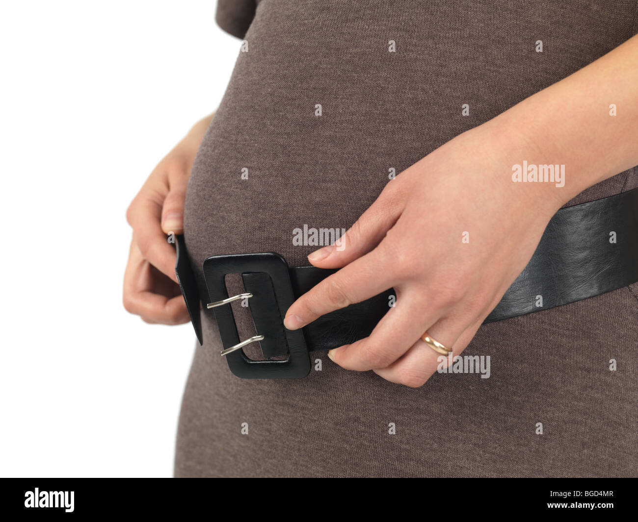 Schwangere junge Frau, die versucht, über ihren Bauch ein Gürtel Schnalle Stockfoto