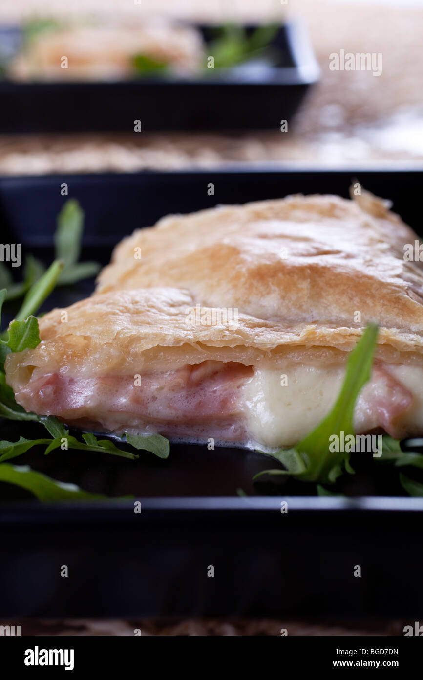 Mortadella, Schinken und Edamer Käse Flan mit frischem Rucola-Salat an der Spitze Stockfoto