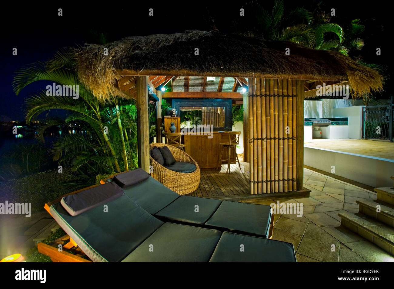 Luxuriöses Herrenhaus außen in der Abenddämmerung mit Bali-Hütte und bar Stockfoto