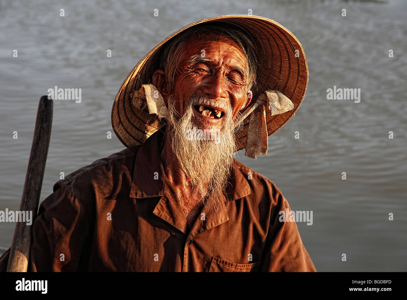 Ältere Menschen, lächelnd Fischer in seinem Boot in den Hafen von Hoi an, Vietnam, Südostasien Stockfoto