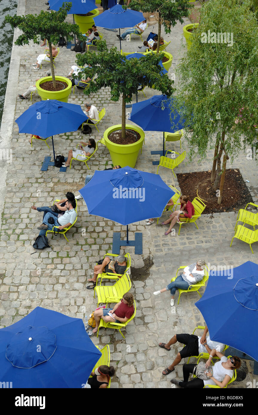 Touristen entspannen, Blue Parasols & Liegestühle am Quai der seine während der "Paris-Plage" Veranstaltungen, Quai de l'Hôtel de Ville, Paris Frankreich Stockfoto