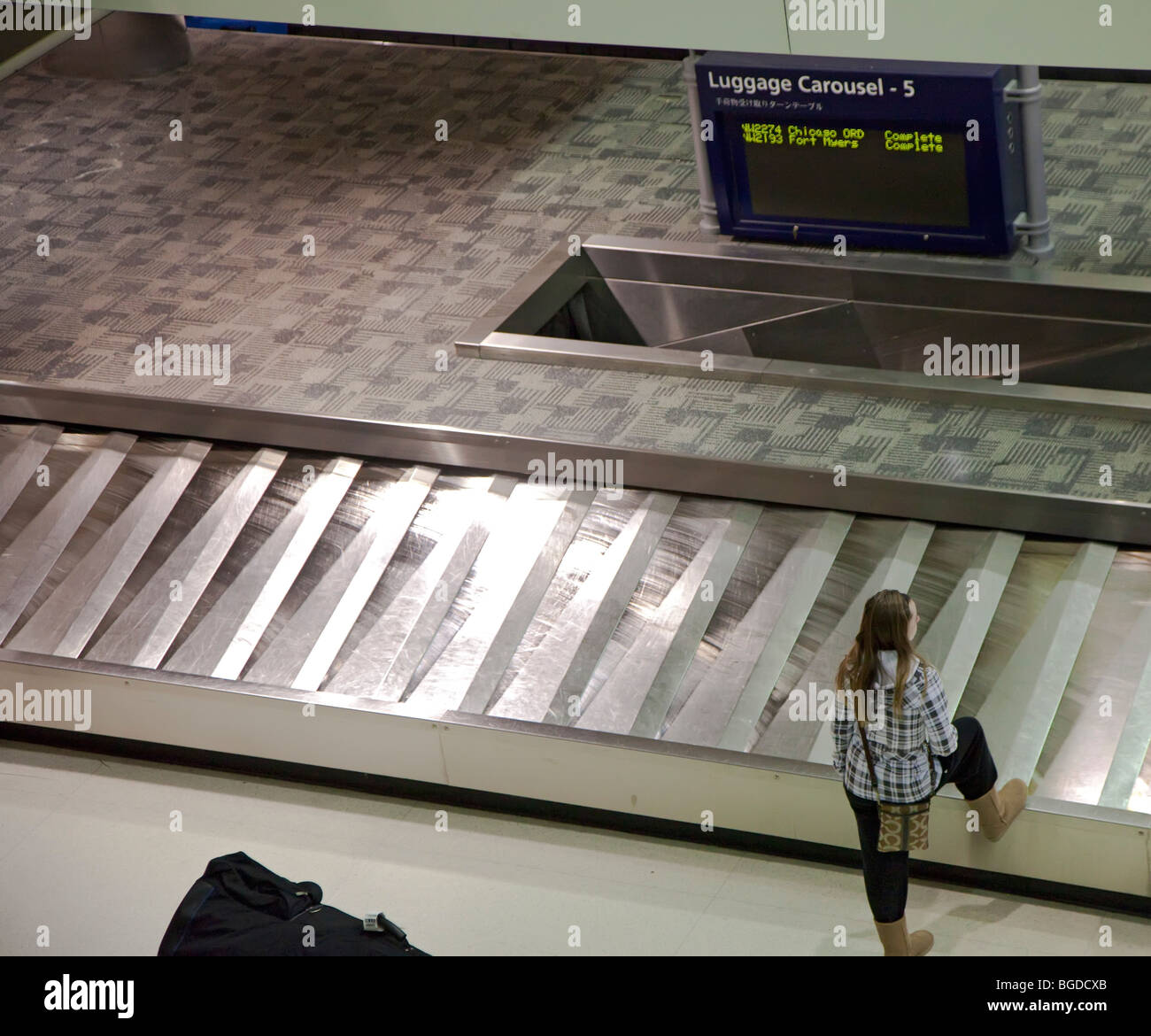 Romulus, Michigan - eine ankommende Reisende wartet ihr Gepäck am Detroit Metropolitan Airport. Stockfoto