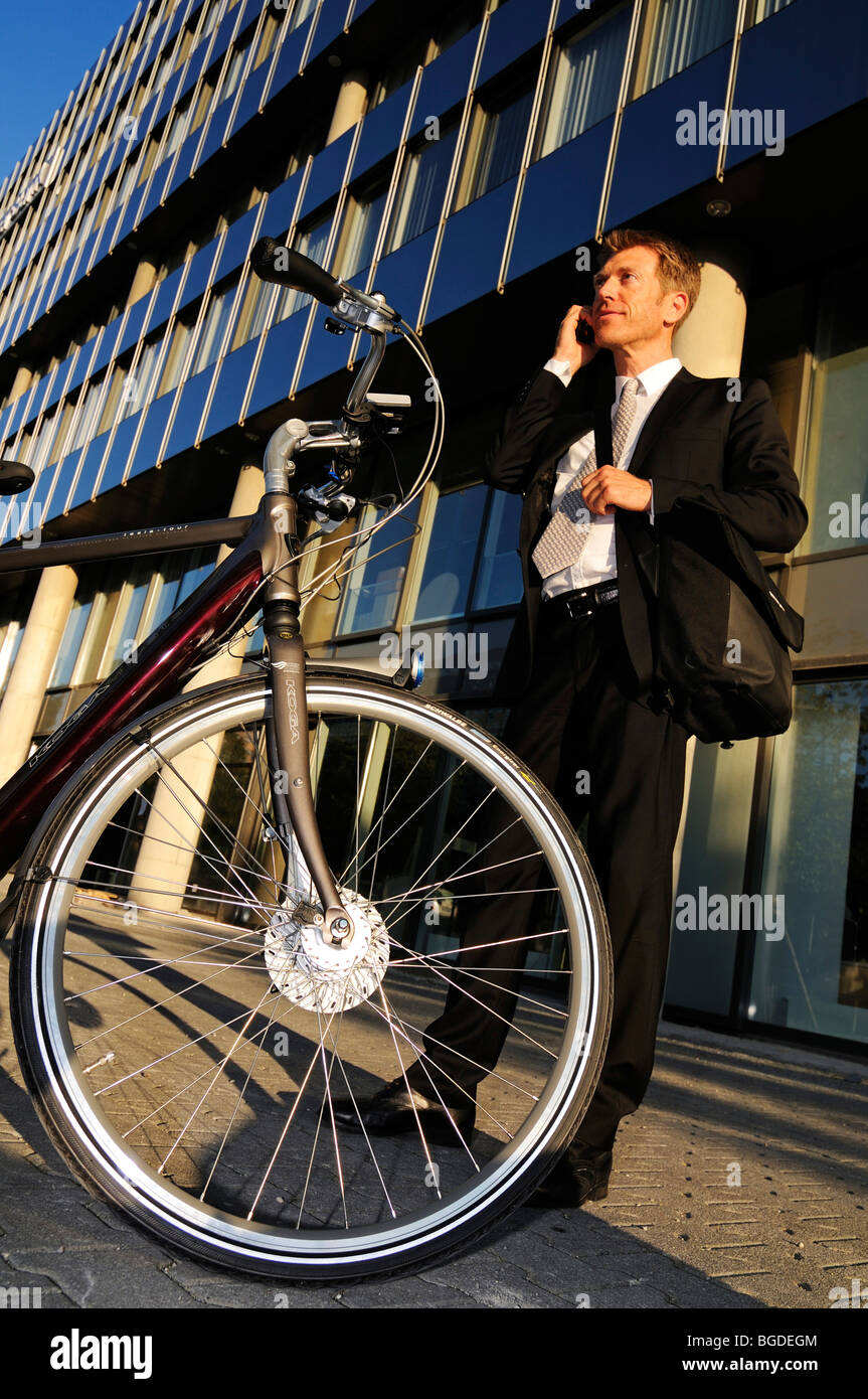 Geschäftsmann mit einem Elektro-Fahrrad, Pedelec, Hypo-Hochhaus bauen, München, Bayern, Deutschland, Europa Stockfoto