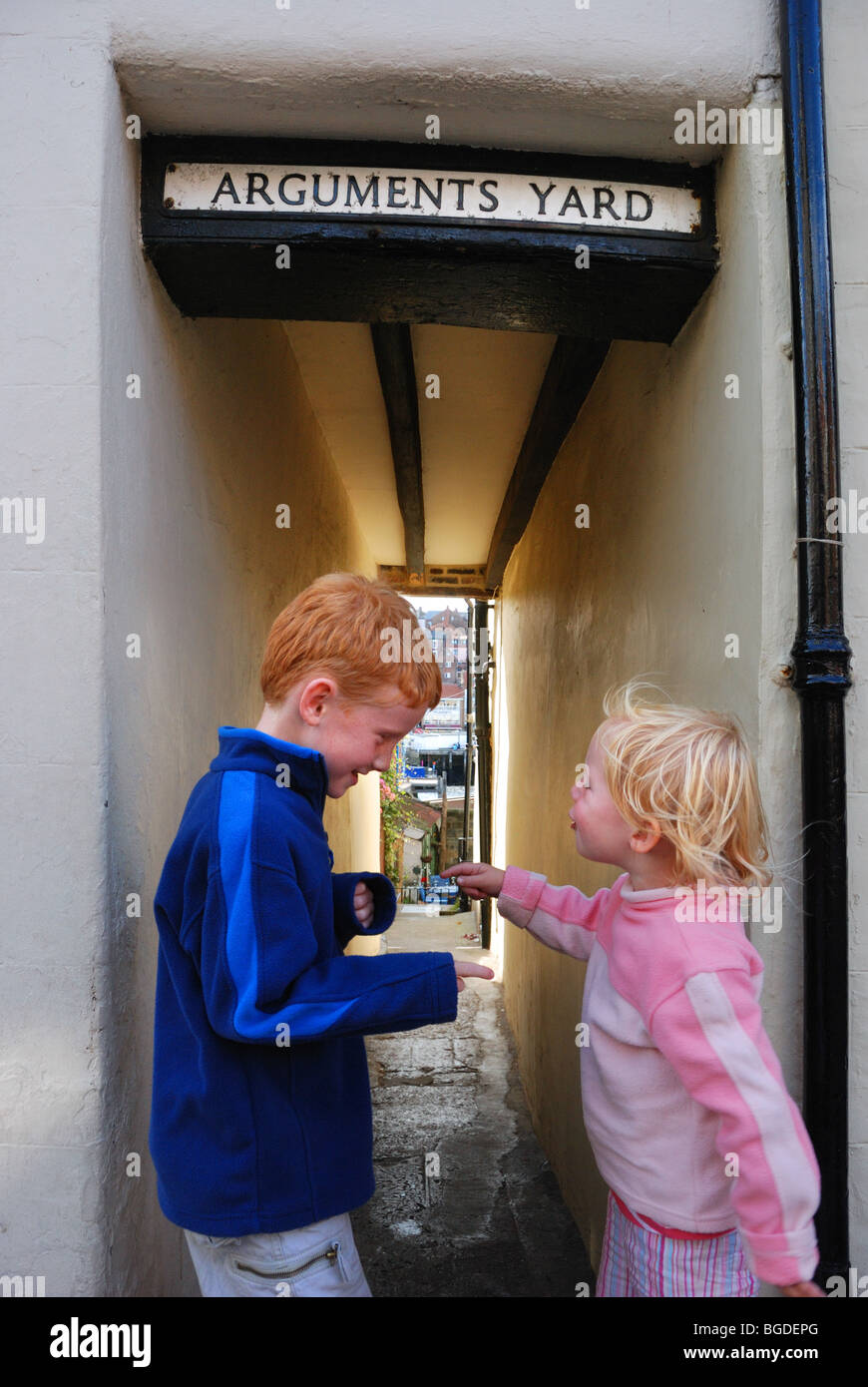 Kinder, die ein Argument in Argumente Hof, eine Straße in Whitby, England Stockfoto