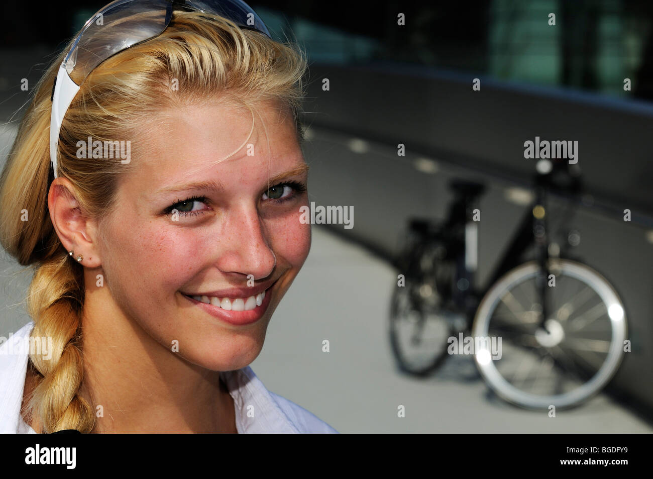 Junge Frau mit dem Fahrrad vor BMW Welt, München, Bayern, Deutschland, Europa Stockfoto