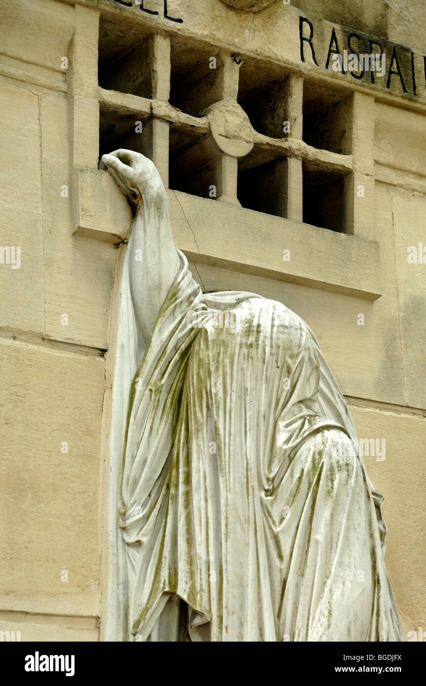 Ghost oder Ghoul, bedeckt mit Grabtuch beim Versuch, ein Grab auf dem Friedhof Pere Lachaise, Menilmontant, Paris, zu betreten oder zu verlassen Stockfoto